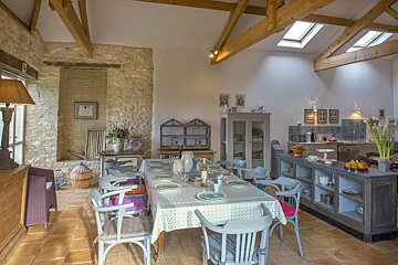A dining room with a table and chairs and a skylight