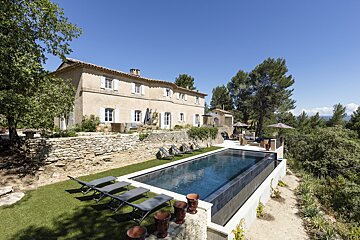 A large house with a large swimming pool in front of it