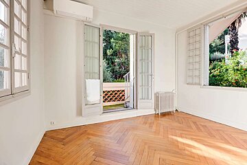 An empty room with hardwood floors and a large window