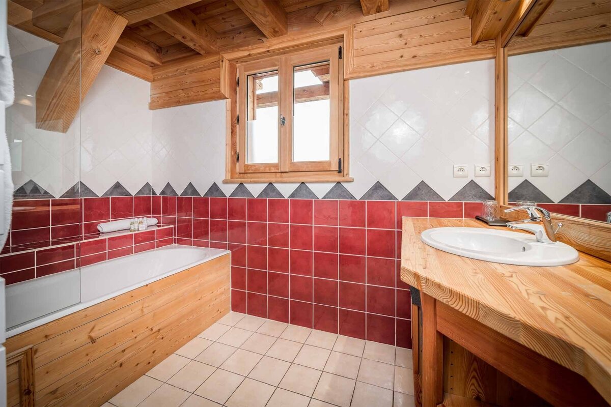 A bathroom with red and white tiles and a sink