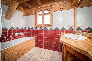 A bathroom with red and white tiles and a sink