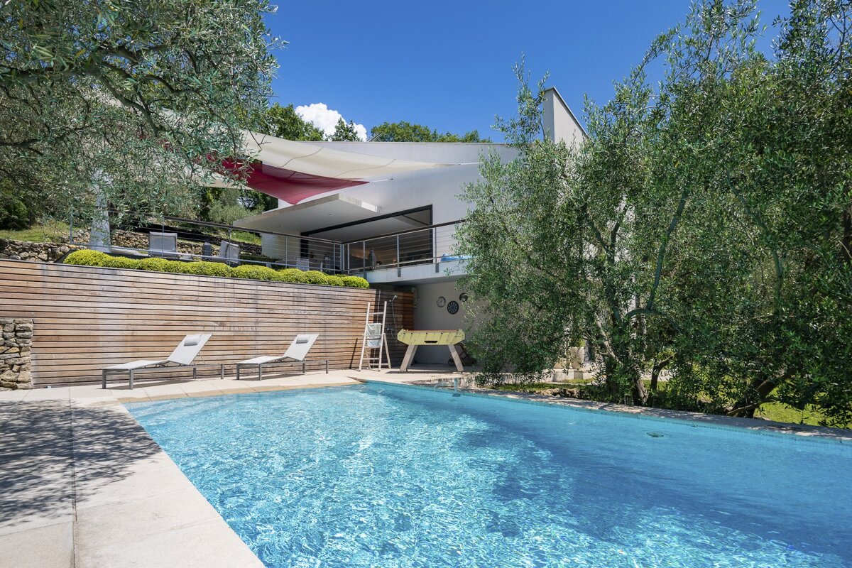 A house with a swimming pool in front of it