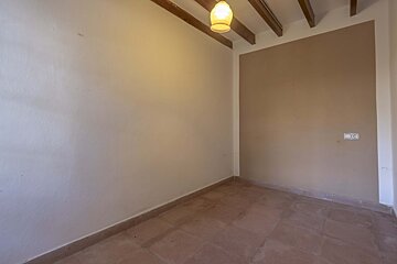 An empty room with a light hanging from the ceiling