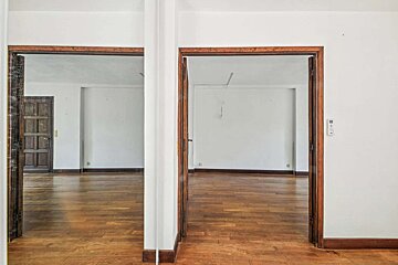 An empty room with wooden floors and white walls