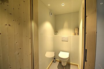 A bathroom with a toilet and two rolls of toilet paper