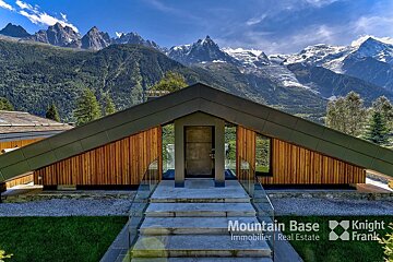 A house with a mountain in the background is for sale by mountain base