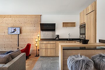 A kitchen with wooden cabinets and a tv with a skier on it