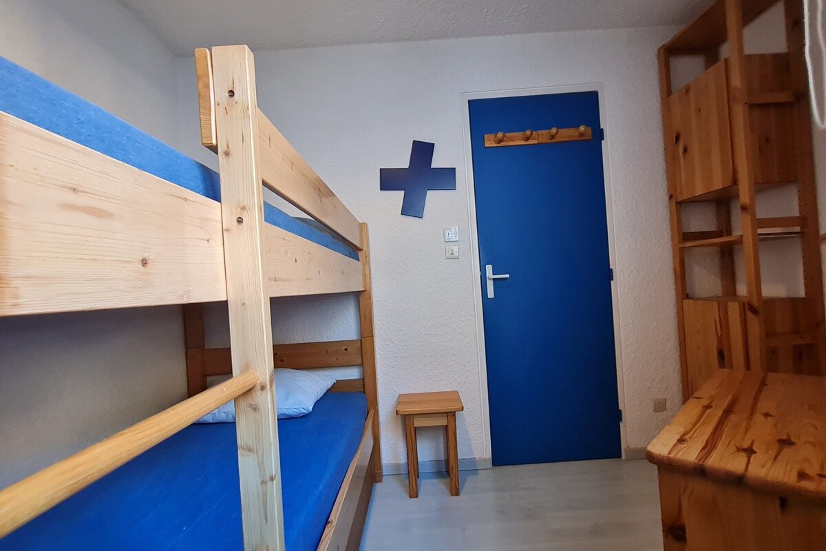 A bedroom with bunk beds and a blue door