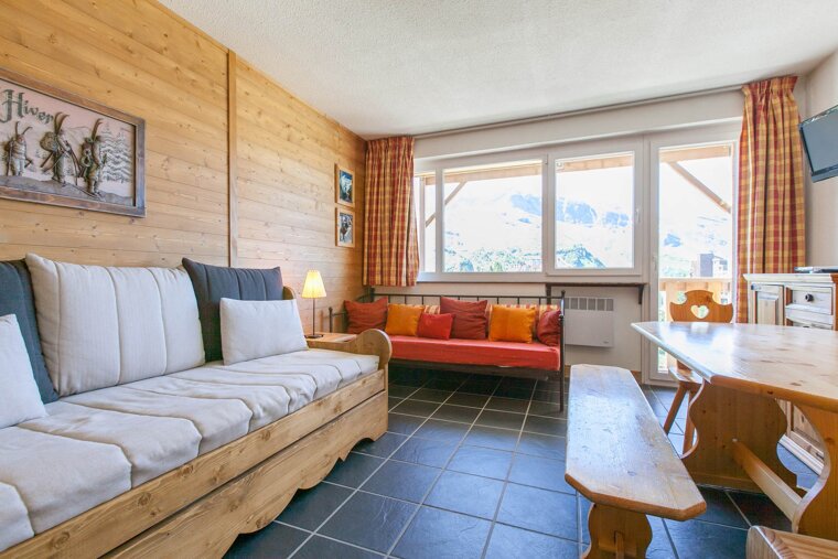 A living room with a couch and a table with a sign on the wall that says hiver