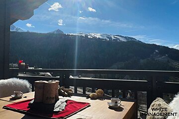A balcony with a view of mountains and trees