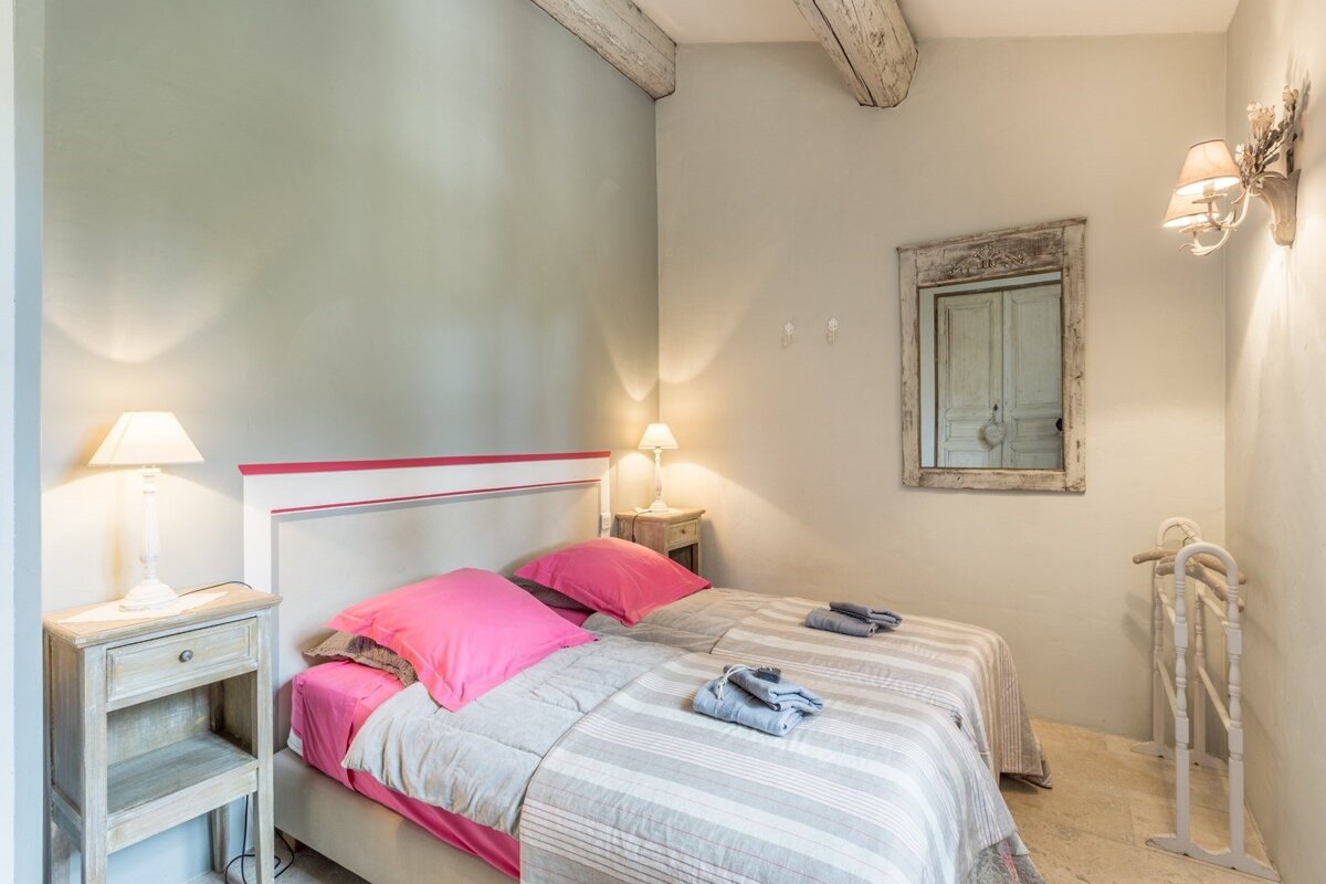 A bedroom with a bed and a mirror on the wall