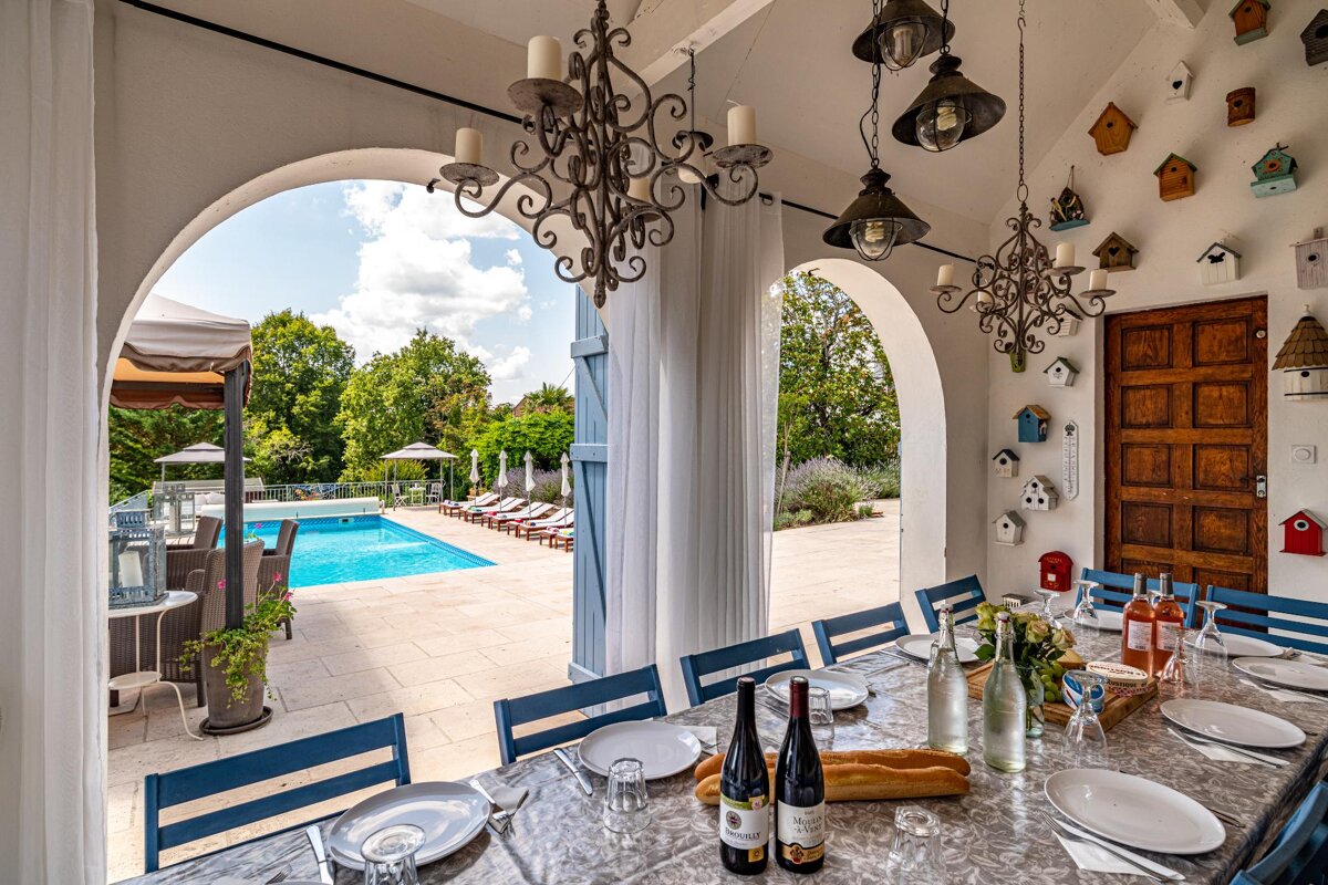 A dining room table with plates and wine bottles on it