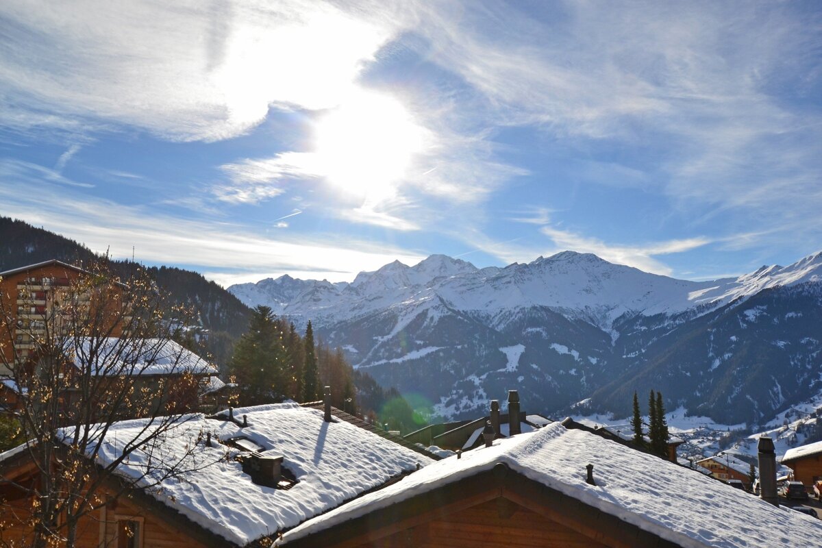 Snow covered roofs with mountains in the background