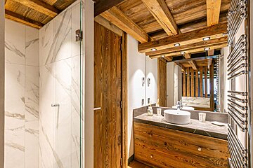 A bathroom with a sink and a mirror with wooden beams