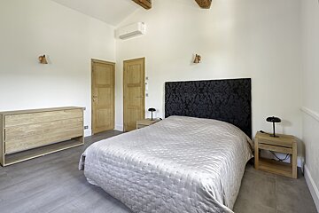 A bedroom with a bed dresser and two nightstands