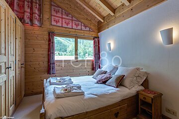 A bedroom with a bed and a window that says tcr80