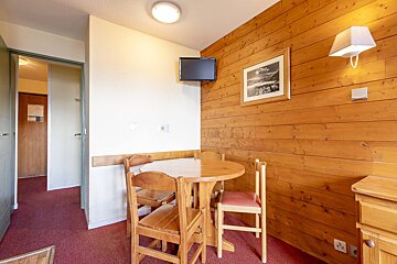 A living room with a red couch a table and chairs