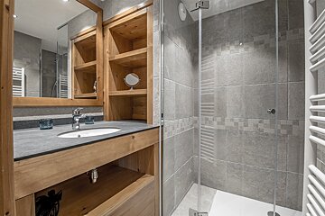 A bathroom with a sink a mirror and a walk in shower
