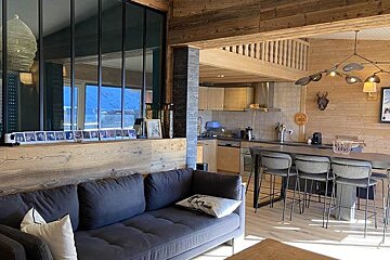 A living room with a couch and a picture of skiers on the wall