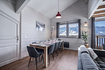 A living room with a dining table and chairs