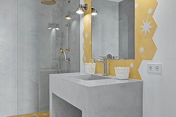 A bathroom with yellow and white tiles and a sink