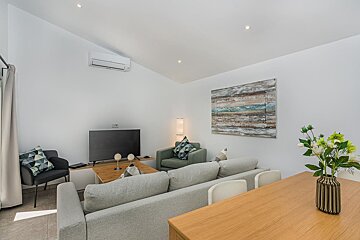 A living room with a couch a chair and a flat screen tv