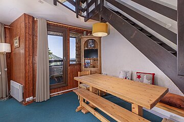 A wooden table in a room with a staircase
