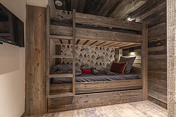 A bunk bed in a room with a flat screen tv