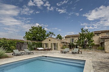 A large house with a swimming pool in front of it