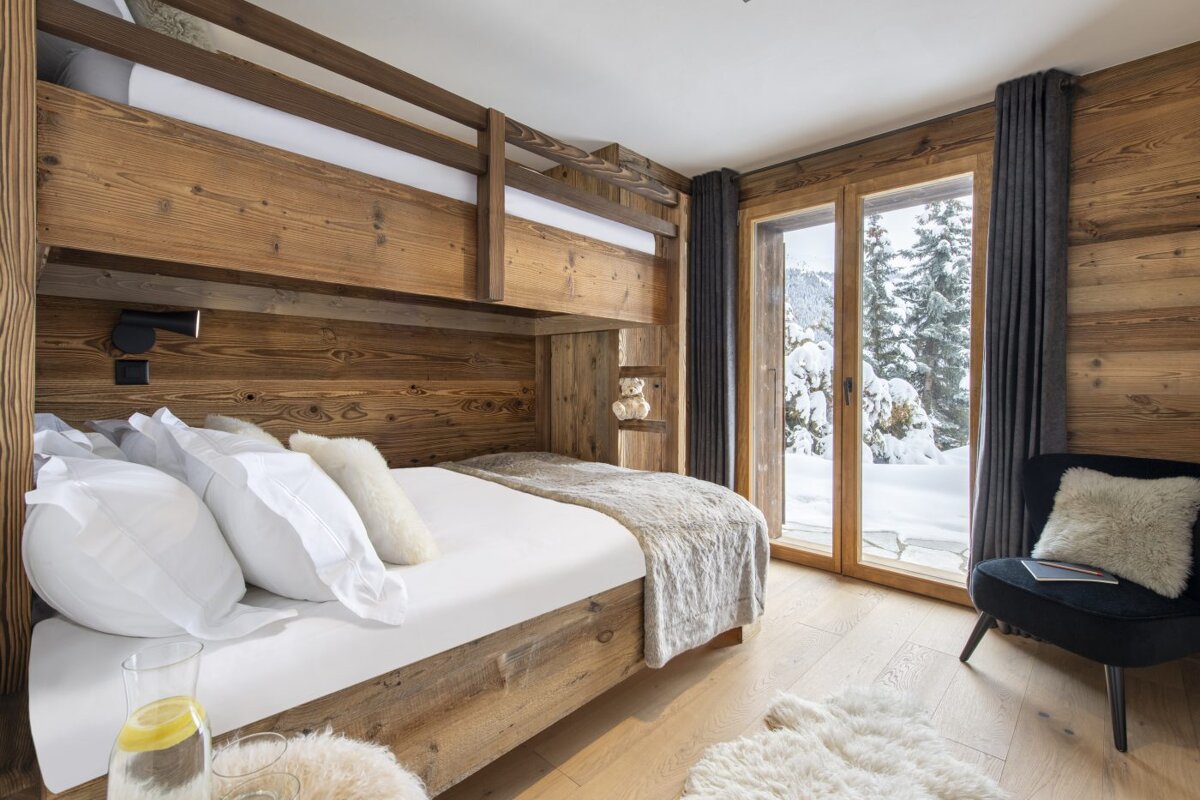 A bedroom with a bunk bed and a chair