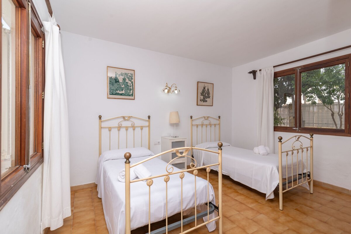 A bedroom with two beds and a picture on the wall