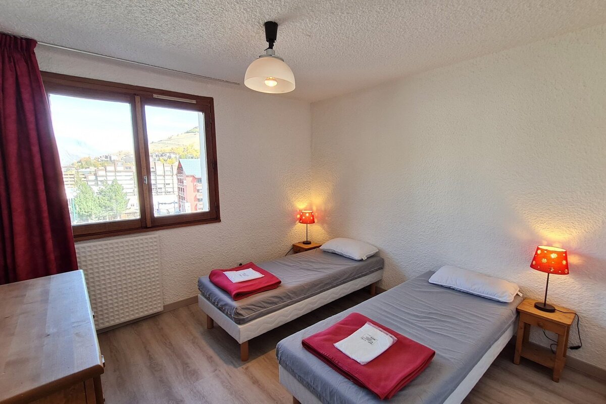 A bedroom with two twin beds and two lamps