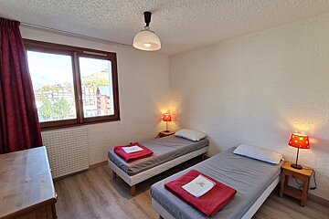 A bedroom with two twin beds and two lamps
