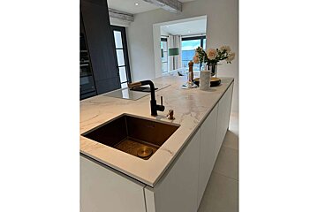 A kitchen with a sink and a vase of flowers on the counter