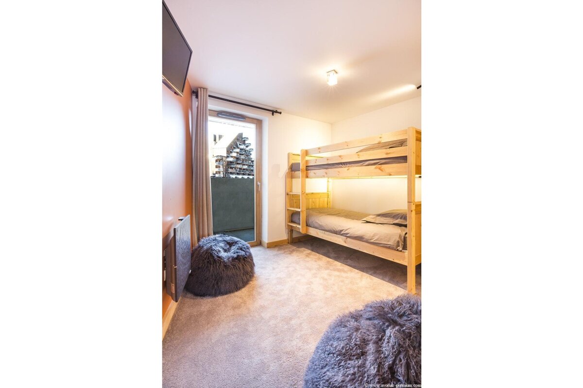A bedroom with bunk beds and a television
