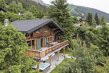 A chalet with a hot tub in front of it