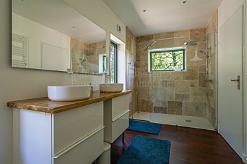 A bathroom with two sinks and a shower with the word immobilier on the bottom