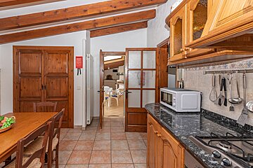 A kitchen with a table and chairs and a microwave