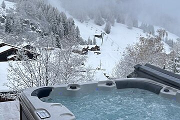 A hot tub with a view of a snowy mountain