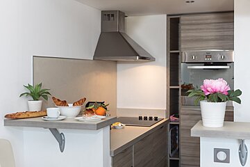 A kitchen counter with a bowl of croissants and a cup of coffee