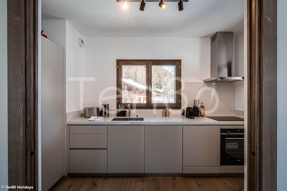 A kitchen with a window and the word ten80 on the wall