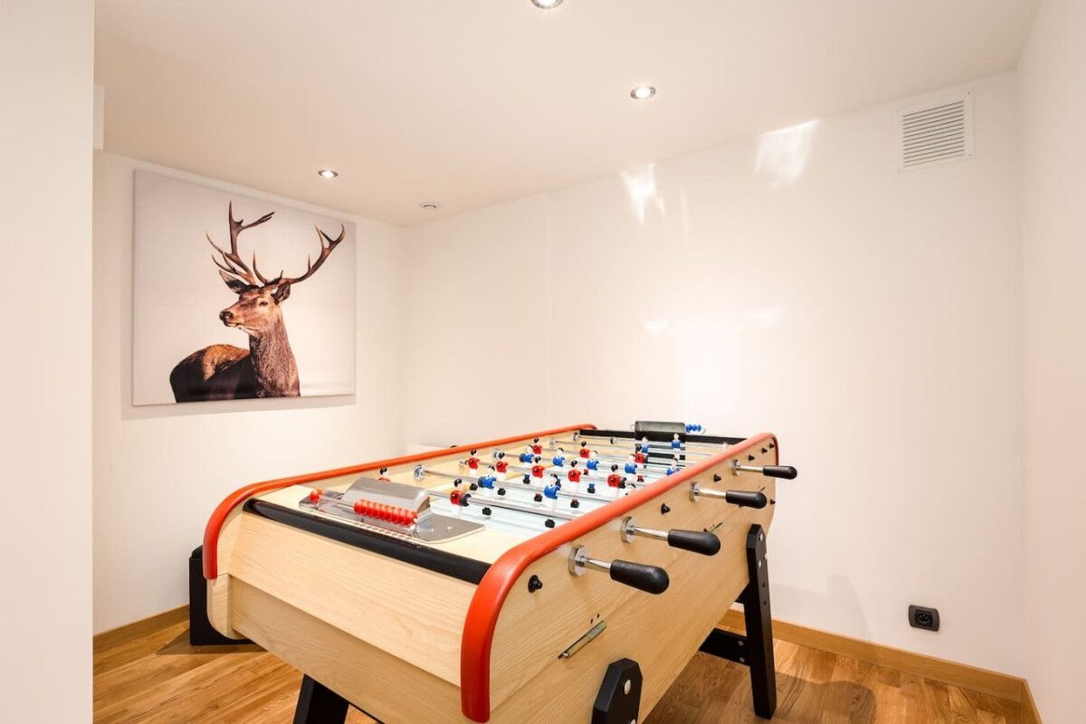 A game table with a picture of a deer on the wall above it