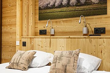 A bed with a picture on the wall above it