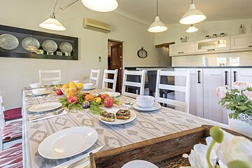 A dining room table with plates and fruit on it