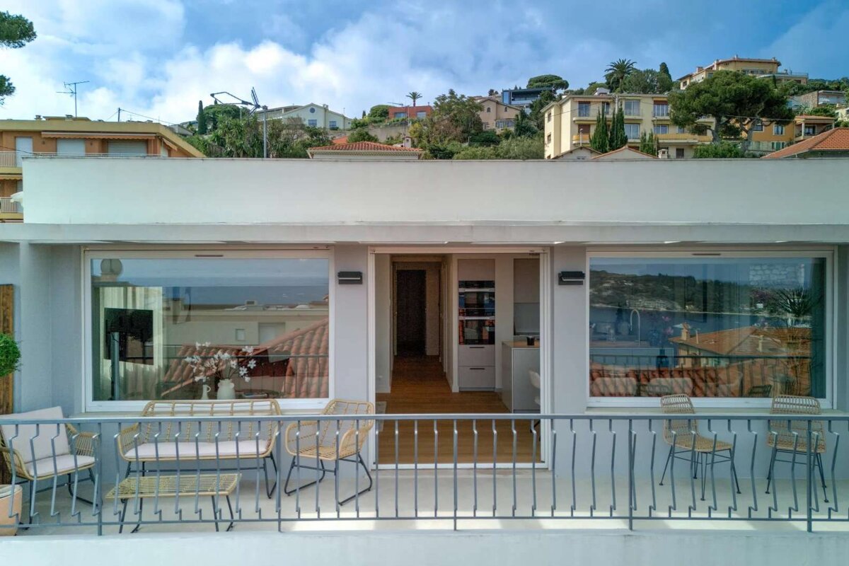 A balcony with chairs and a table with a view of a city