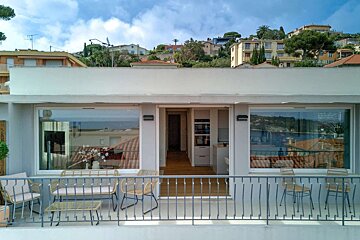 A balcony with chairs and a table with a view of a city