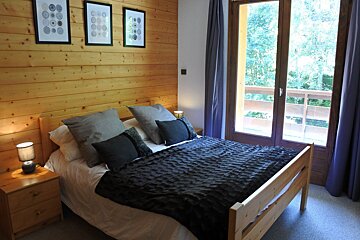 A bedroom with a large bed and a balcony