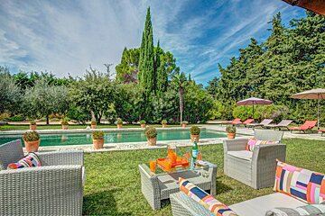 A large swimming pool surrounded by chairs and umbrellas