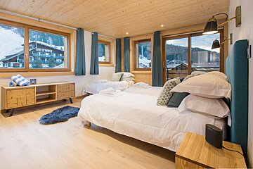 A bedroom with two beds and a view of the mountains