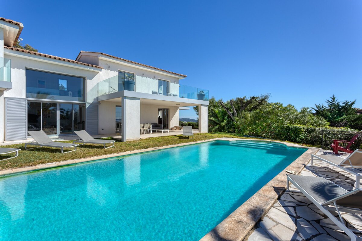 A large house with a swimming pool in front of it